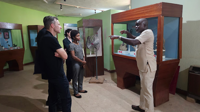 A tour guide showcasing the National Museum of Unity Enugu arts.